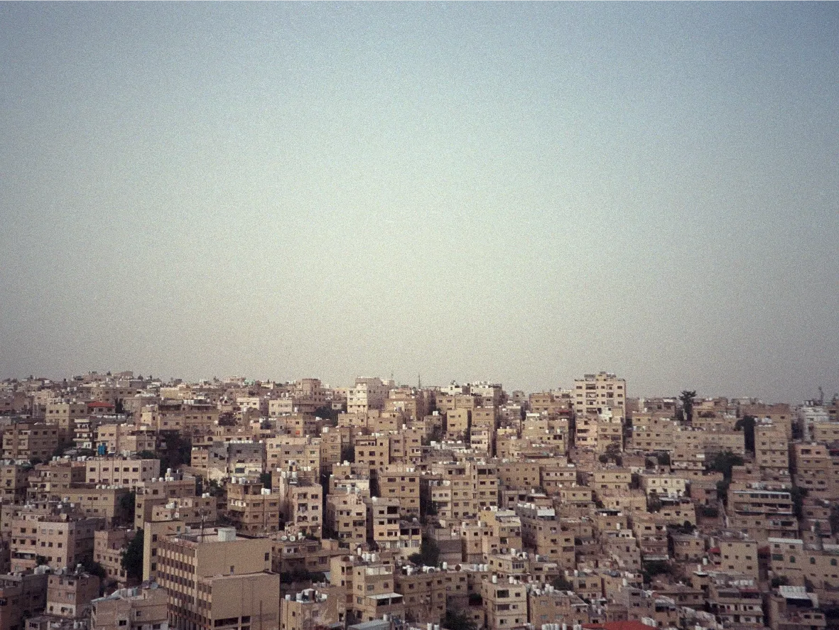 A dense hillside cityscape of tan buildings stretching to the horizon.