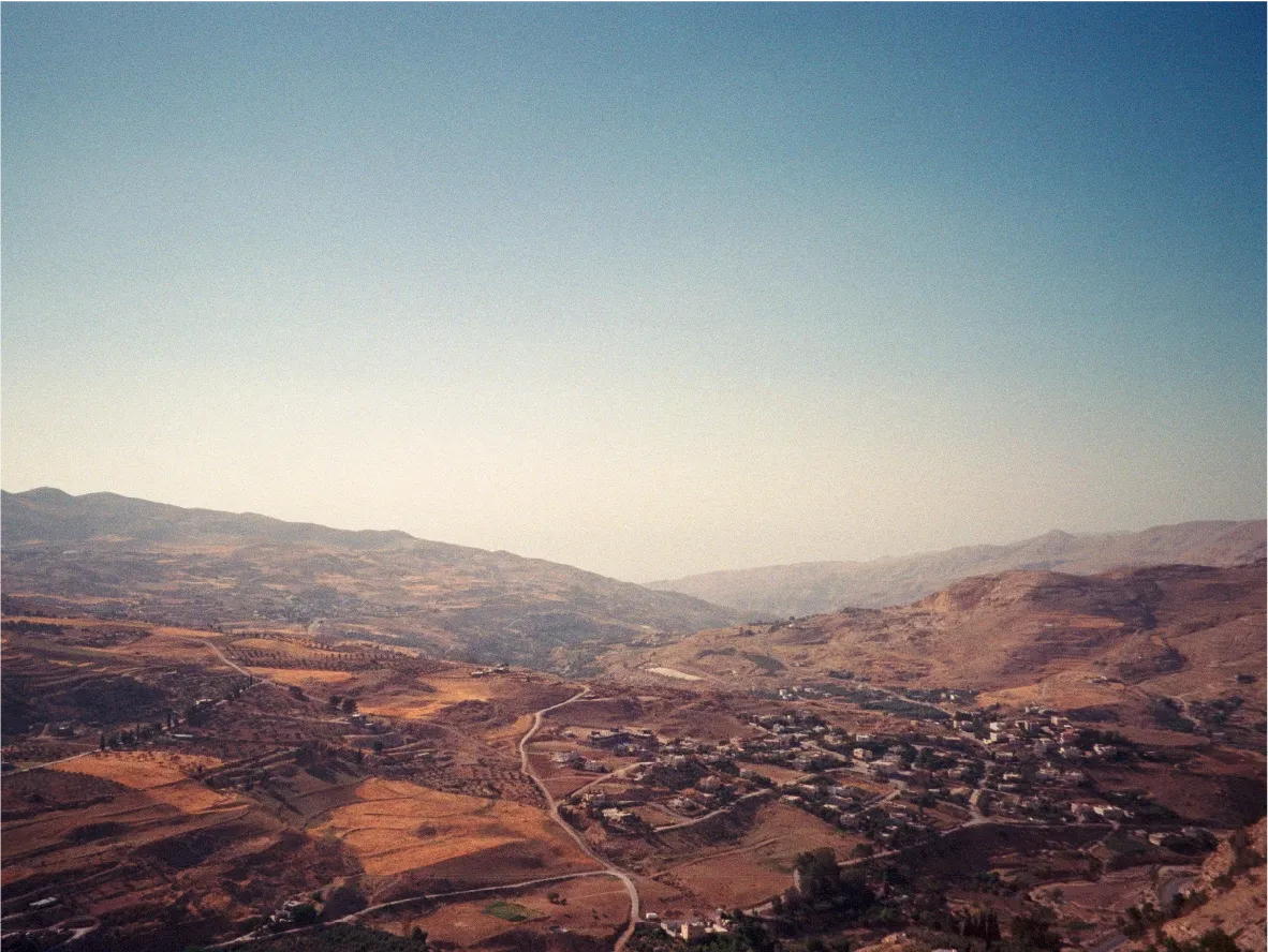 An overlook of a valley village nestled among terraced hills.