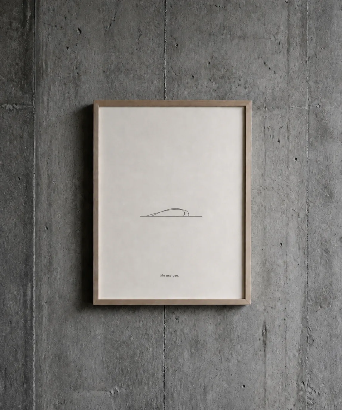Framed line drawing 'Me and you.' — two curved strokes meeting over a horizon line — hung on a concrete wall.